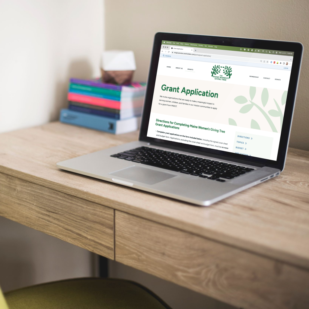 A laptop on a desk with the grant application open